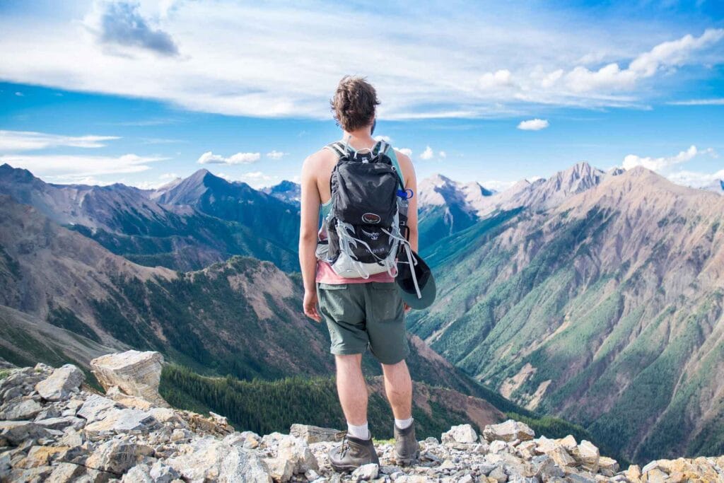 a man standing at the peak of a mountain